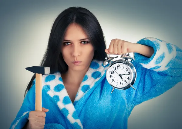 ハンマー、目覚まし時計を保持している若い女性 — ストック写真