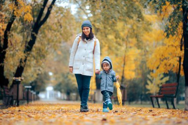 Mutlu Anne ve Çocuk Sonbahar sezonunda Parkta Yürüyüşü
