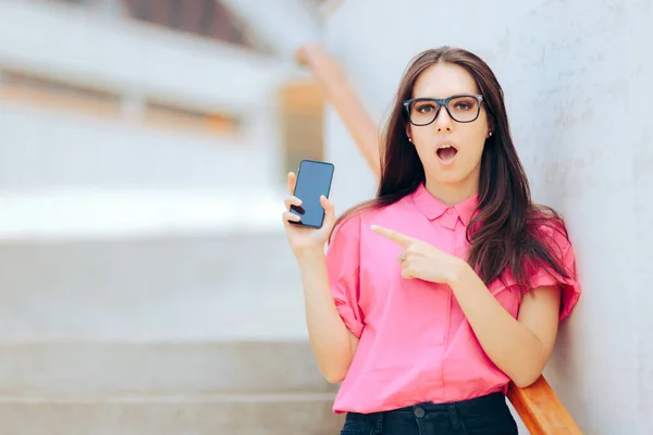 彼女のスマートフォンのディスプレイを指す陽気なビジネスマンの女性 — ストック写真