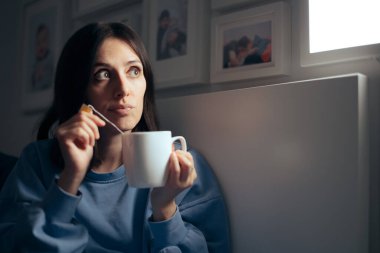 Uykusuzluk için çay içen kadın yatak odasında oturuyor.