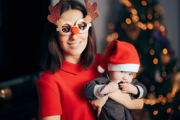 Mãe Vestindo Óculos Engraçados Segurando Seu Bebê Celebrando Natal — Fotografia de Stock