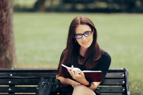 若い女性が公園のベンチでの読書 — ストック写真