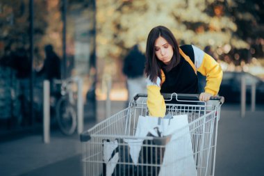 Bir şey almayı unutan bir kadın alışveriş arabasını kontrol ediyor.