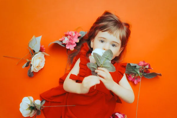 Menina Bonito Vestindo Vestido Vermelho Cheirando Uma Flor Rosa — Fotografia de Stock