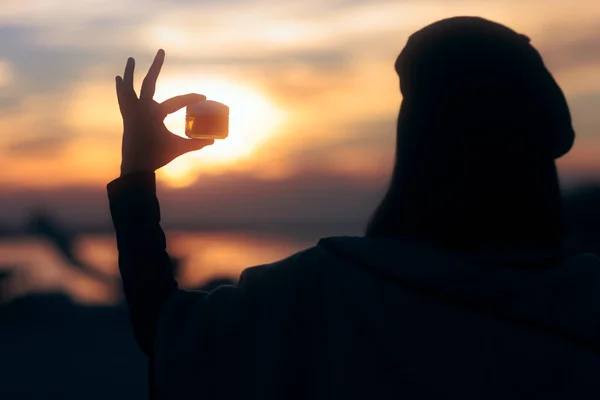 Silhouet Van Een Vrouw Die Een Beschermende Crème Pot Vasthoudt — Stockfoto