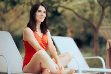 Mutlu Kadın Havuz kenarındaki Lounge sandalyesinde oturuyor