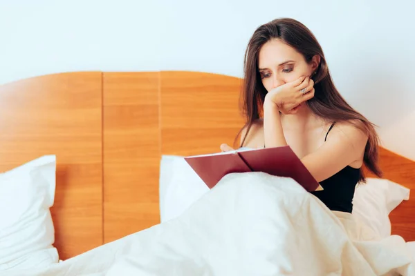 Sad Depressed Woman Sitting in Bed Writing in her Journal