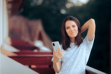 Acı içinde uyanan yorgun kadın akıllı telefonunu kontrol ediyor.