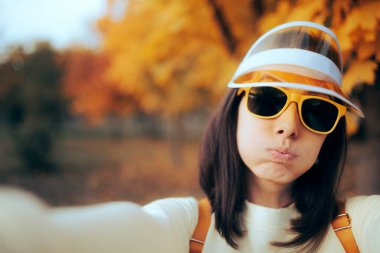 Funny Woman Wearing Sunglasses and Visor Taking a Selfie Outdoors