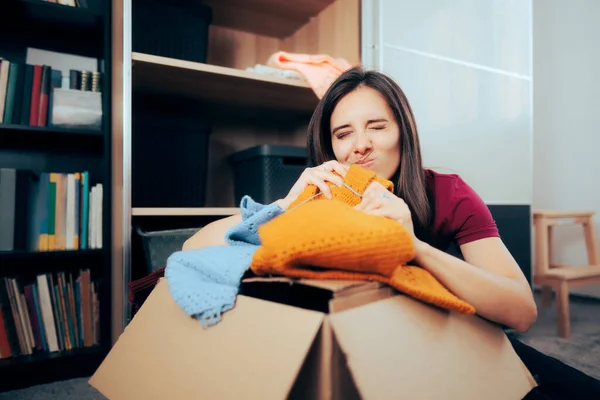 Woman Smelling Old Clothes Being Deposited Moving Boxes — Photo