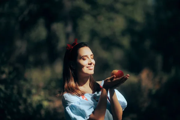 Beautiful Modern Snow-White Princess Holding an Apple in the Woods