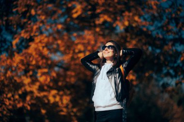 Smiling Woman Wearing Leather Jacket and Sunglasses Enjoying Autumn