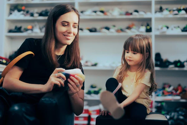 Mother Buying Shoes for Her Little Toddler Daughter