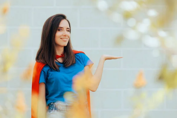 Beautiful Super Woman Holding Her Palm in Presentation Gesture