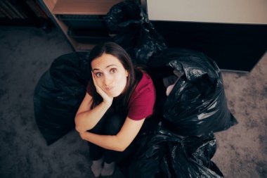 Stressed Woman Feeling Nostalgic about Throwing Away Old Things