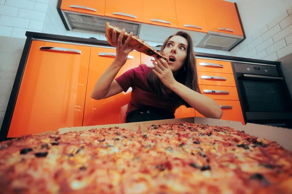 Wanita Duduk Lantai Dapur Sedang Makan Sepotong Pizza — Stok Foto