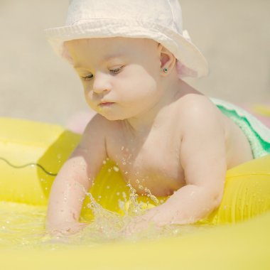 Neşeli küçük bebek kız havuzda oynarken Downs Sendromu