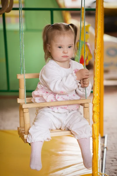 Girl with Down syndrome is riding on a swing — Stock Photo, Image