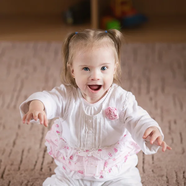 Маленькая позитивная девочка с синдромом Дауна — стоковое фото