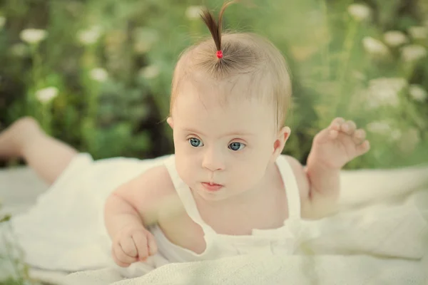 Little girls have Down syndrome rest on the nature — Stock Photo, Image