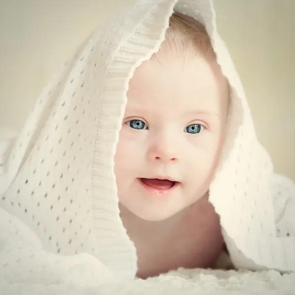 Little baby with Down syndrome hid under blanket — Stock Photo, Image