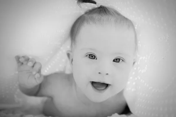 Little baby with Down syndrome hid under blanket — Stock Photo, Image