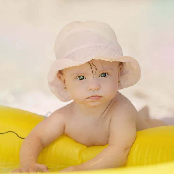 Веселая маленькая девочка с синдромом Даунса играет в бассейне — стоковое фото