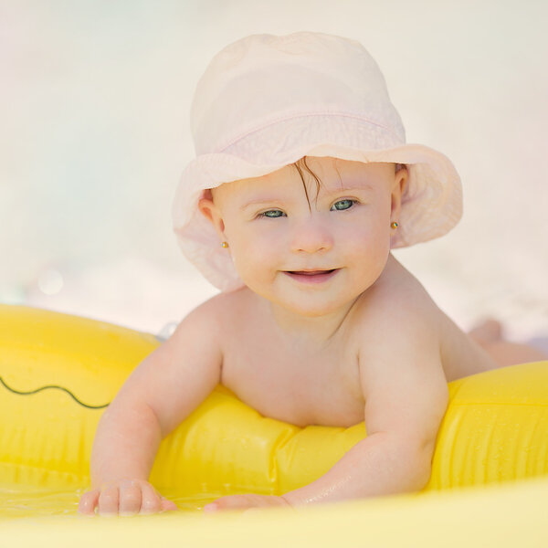 Веселая маленькая девочка с синдромом Даунса играет в бассейне
