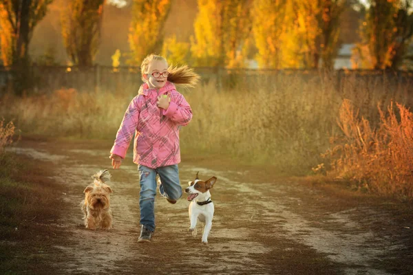 Belle fille avec le syndrome de Down avec son animal de compagnie Jack Russell terrier court à la course — Photo