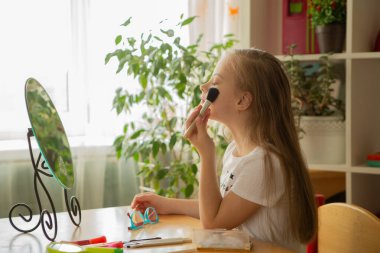 Down sendromlu güzel bir kız aynanın önünde tarak kullanıyor.