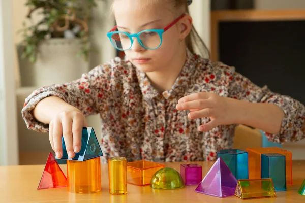 Girl with Down syndrome playing with geometrical shapes — Stock Photo, Image