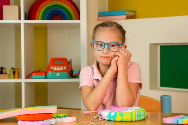 A girl with Down syndrome plays with popit — Stock Photo, Image