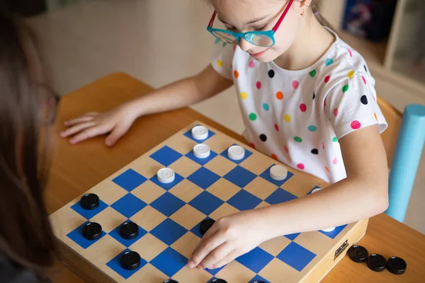 Chica con síndrome de Down jugando damas — Foto de Stock