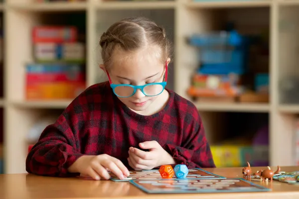 Chica con síndrome de Down juega juegos de mesa en cuarentena —  Fotos de Stock