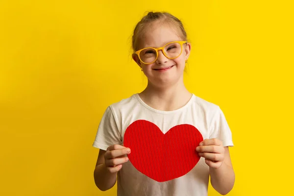Chica Con Síndrome Sosteniendo Gran Corazón Papel Rojo Sobre Fondo — Foto de Stock
