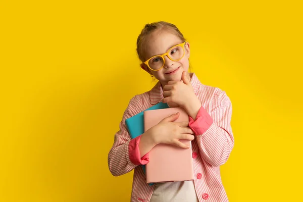 Dziewczyna Zespołem Downa Podręcznikami Przygotowuje Się Szkoły Zdjęcie Żółtym Tle — Zdjęcie stockowe