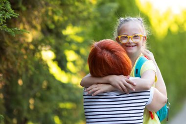A girl with Down syndrome hugs her grandmother who met her after school clipart