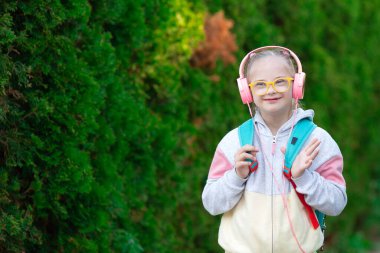 Girl with Down syndrome listens to music clipart