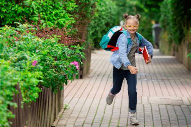 A girl with Down syndrome goes to school with a backpack