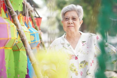 Dekoratif kağıt feneri olan Asyalı yaşlı yaşlı bir kadın.