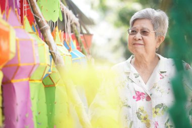 Dekoratif kağıt feneri olan Asyalı yaşlı yaşlı bir kadın.