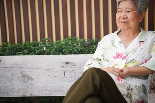亚洲老年老年妇女在花园里休息休息 老年人休闲生活方式 图库图片