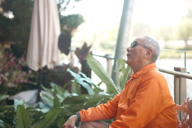 Yaşlı kıdemli yaşlı adam terasta dinleniyor. olgun emeklilik yaşam tarzı