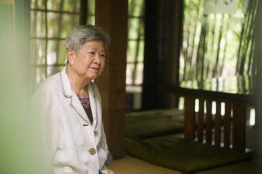 Yaşlı yaşlı yaşlı yaşlı kadın teras avlusunda dinleniyor. olgun emeklilik yaşam tarzı