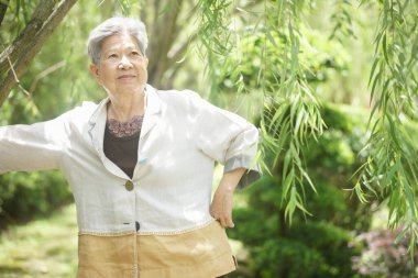 Yaşlı yaşlı yaşlı yaşlı kadın dinleniyor bahçede yürüyor.