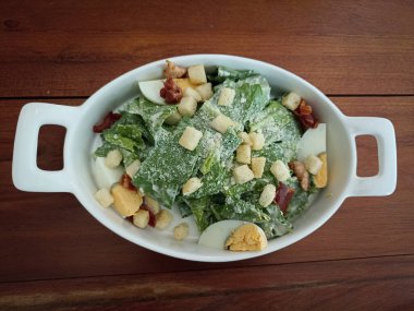 Caesar vegetable salad with parmesan cheese lettuce egg bread ham