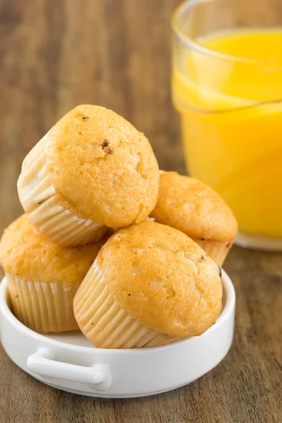 Fresh chocolate chip muffins with a glass of orange juice — Stock Photo, Image