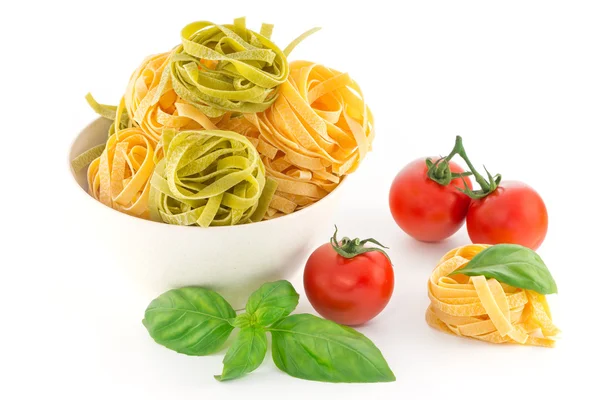 Italienische Pasta Tagliatelle Nest und Kirschtomaten isoliert auf whi — Stockfoto