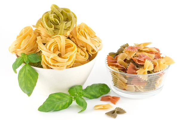 Italian pasta and basil leaves isolated on white background — Stock Photo, Image