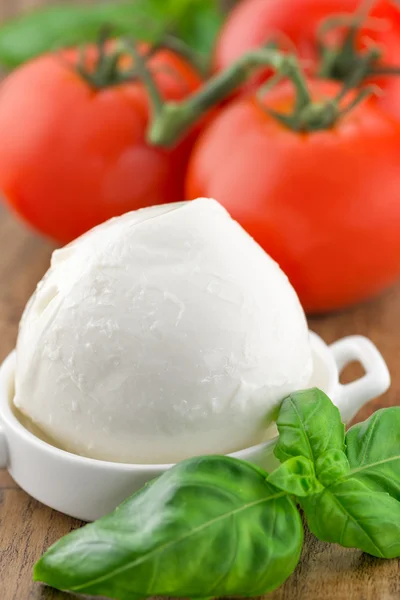 Tomaten und Mozzarella mit Basilikumblättern auf einem Teller — Stockfoto